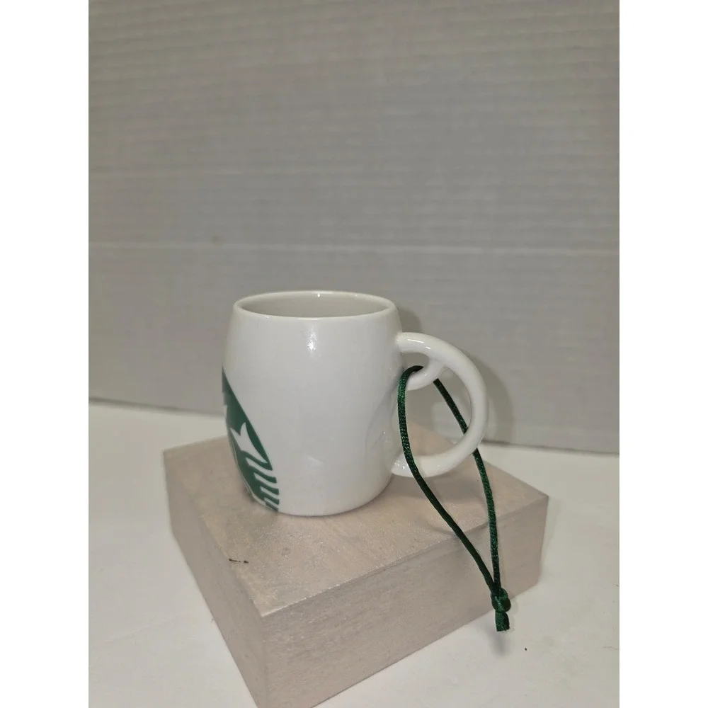 white‎ ceramic Starbucks ornament featuring a green siren logo